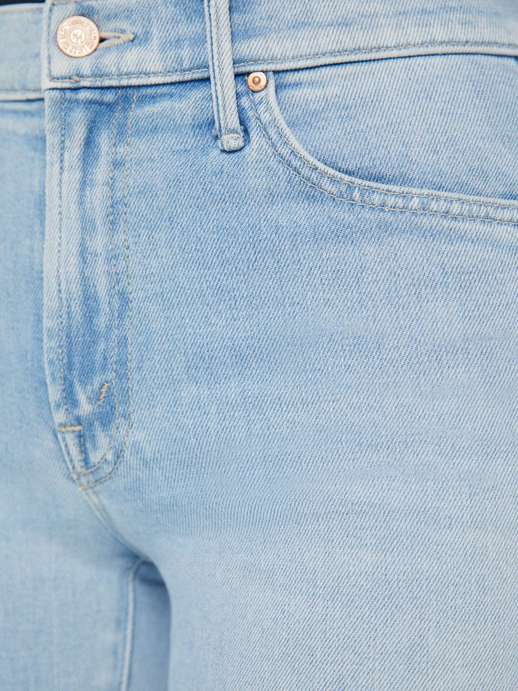 Detailed view of a high-rise light blue bootcut jean with whiskering and fading.