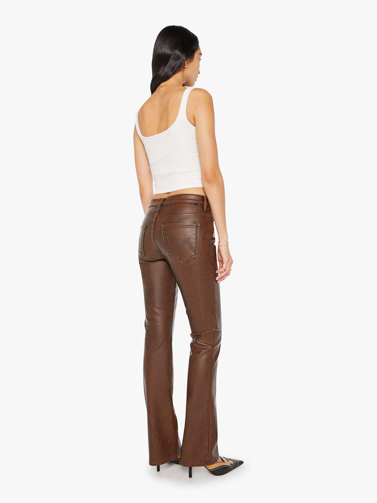 Back view of a woman in a faux dark chocolate brown high waisted bootcut with a 32-inch inseam and a clean hem.