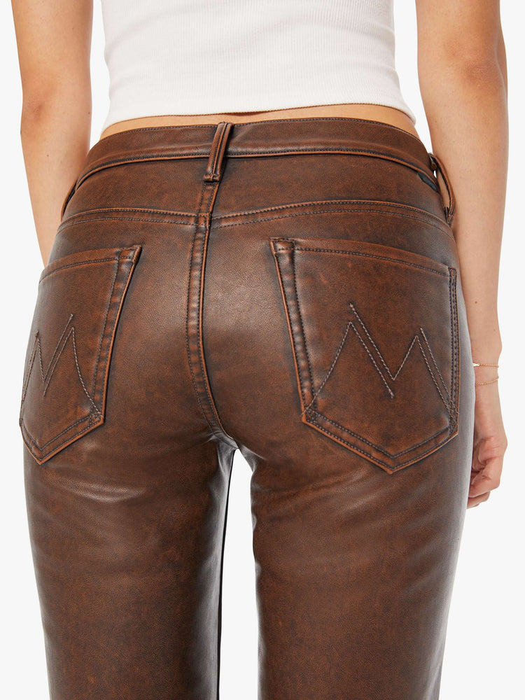 Back view of a woman in a faux dark chocolate brown high waisted bootcut with a 32-inch inseam and a clean hem.