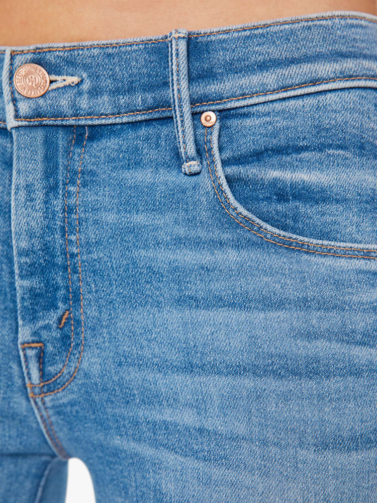 Swatch view of a woman super low-rise flares have a 32-inch inseam and a clean hem in a mid blue wash.