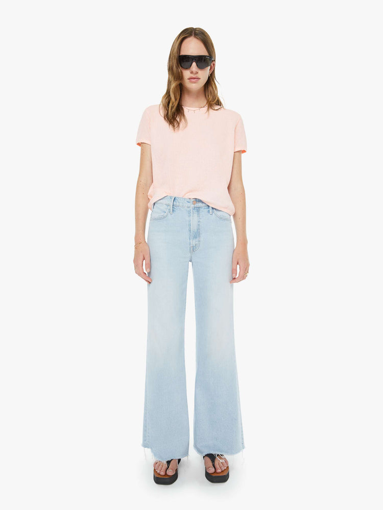 Front view of a woman in a light blue wide leg jeans with a zip fly, high rise, 31-inch inseam and a frayed hem. 