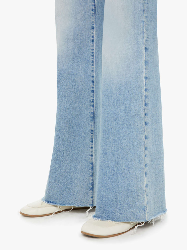 Swatch view of a light blue wide leg jean with whiskering, fading, distressed details and a frayed hem paired with flats.