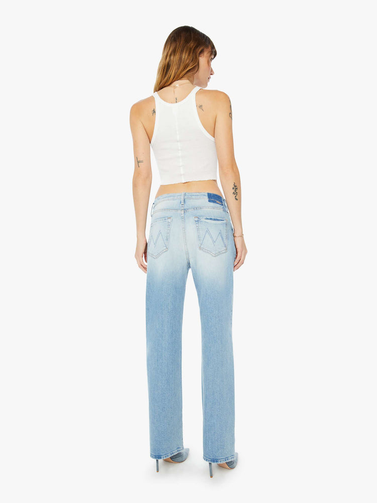 Back view of a womens light blue wash jean featuring a slouchy low rise fit, wide straight legs, and a long clean hem.