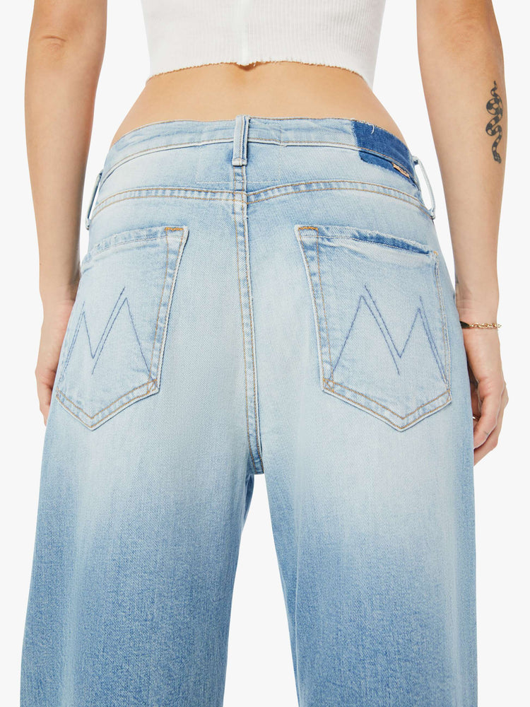 Back close up view of a womens light blue wash jean featuring a slouchy low rise fit.