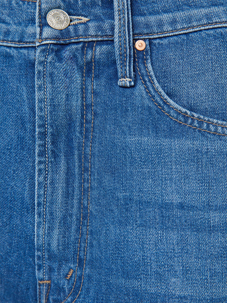 Swatch view of a woman in a mid blue designed to sit on the hips with a slouchy fit, these jeans feature a flared leg, zip fly, ankle-length inseam and a super high rise with a slightly dropped crotch.