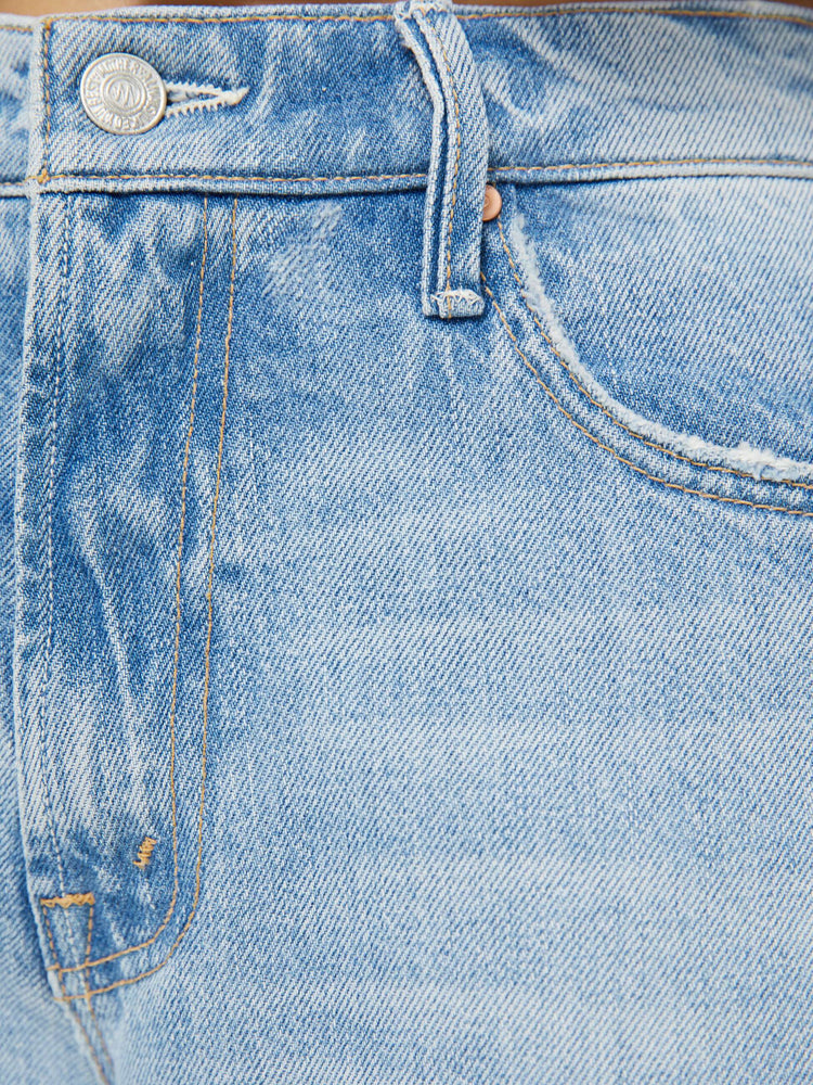 Swatch view of a woman in a light blue mid-rise jeans with a loose fit, zip fly, wide leg and 32-inch inseam with a clean hem.