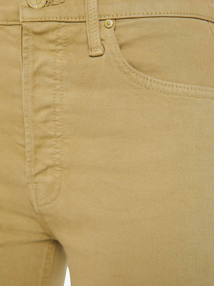 Detailed view view of a woman in warm khaki high-rise flare with a button fly and a frayed hem.