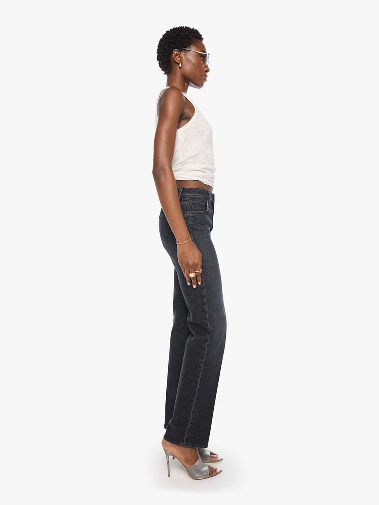 Side view of a woman in a washed black high-rise jeans with a straight leg, zip fly and a 32-inch inseam with a clean hem.