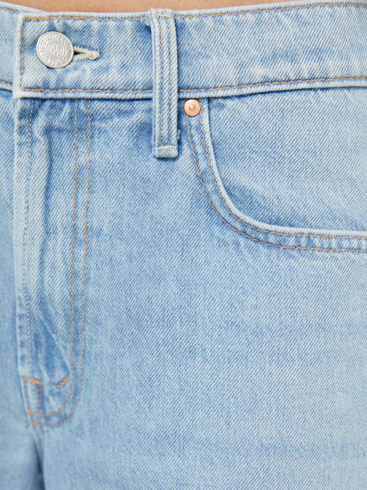 Swatch view of a woman in a light blue mid-rise jeans with a wide straight leg, zip fly and frayed ankle-length inseam.