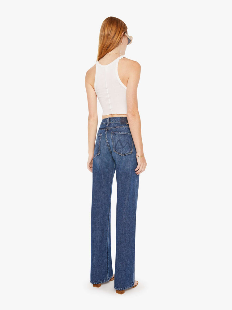 Back view of a pair of dark blue jeans featuring a wide bootcut and a slouchy relaxed fit.