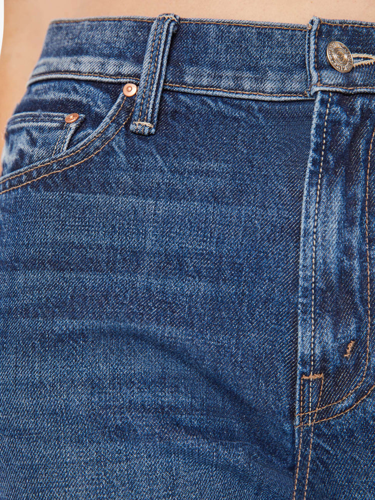 Close up detail view of a dark blue denim jean.