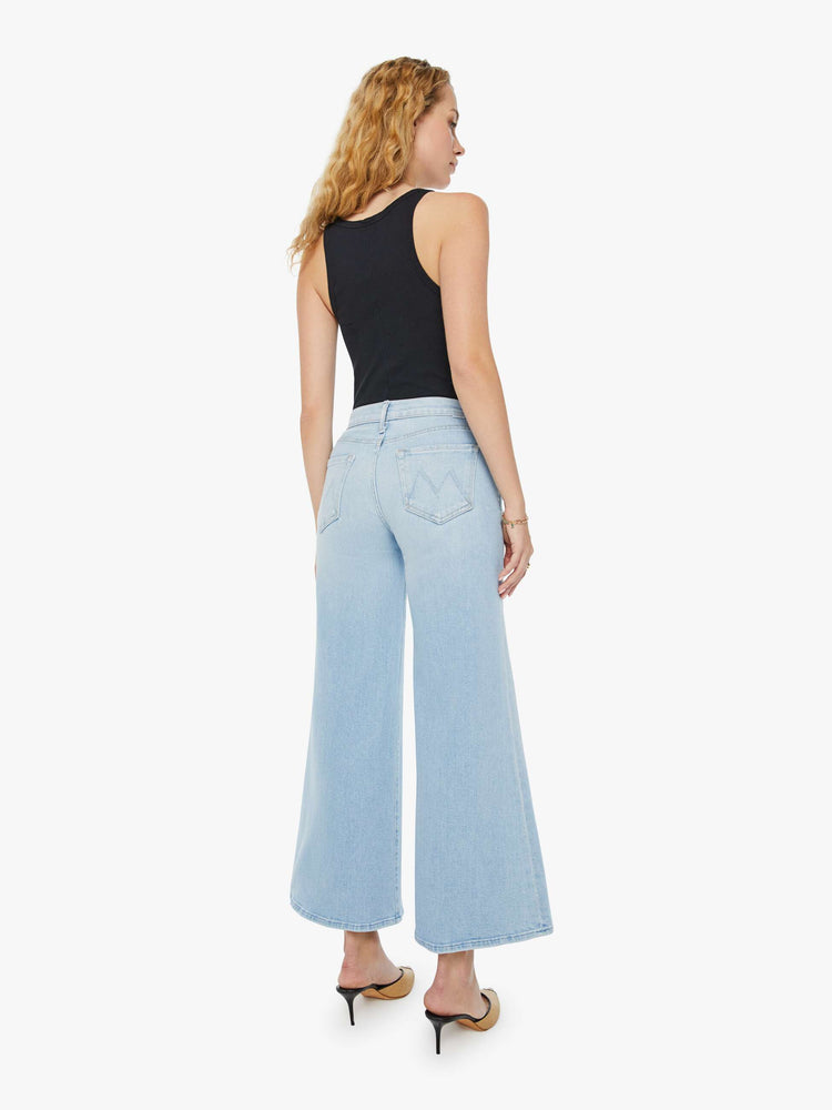 Back view of a woman in light blue high-rise jeans with a wide leg and a clean hem.