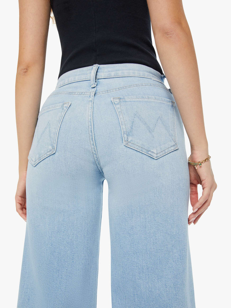Swatch view of a woman in light blue high-rise jeans with a wide leg and a clean hem.