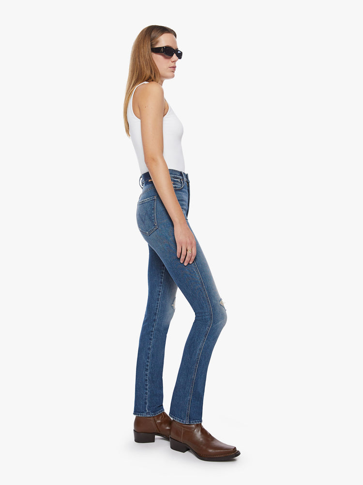 Side view of a woman high-rise slim-straight leg has a long 34-inch inseam with a clean hem in a dark blue wash.