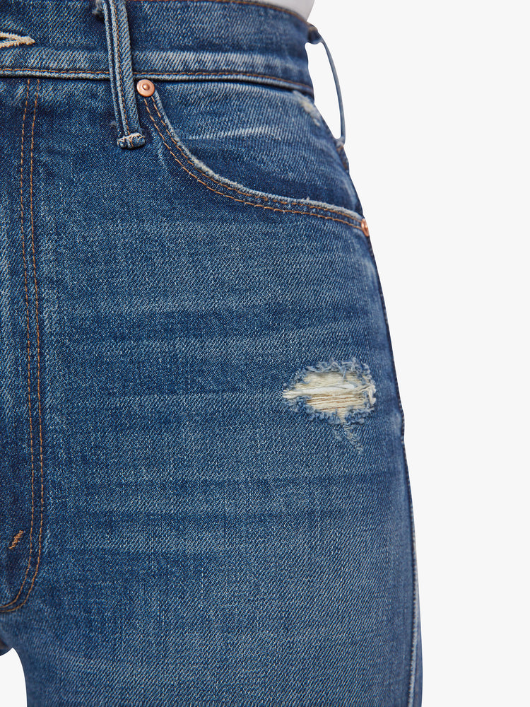 Close up pocket view of a woman high-rise slim-straight leg has a long 34-inch inseam with a clean hem in a dark blue wash.