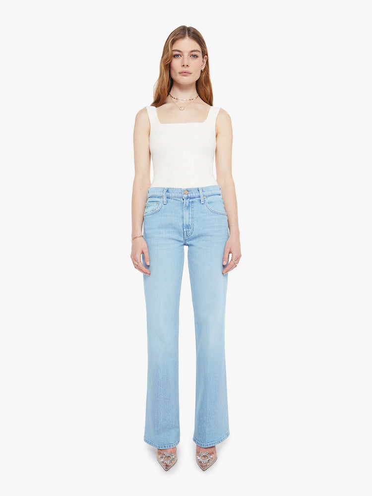 Front view of a woman in a light blue  jean with a high-rise bootcut with a zip fly, looser leg and a long 32-inch inseam with a clean hem. 