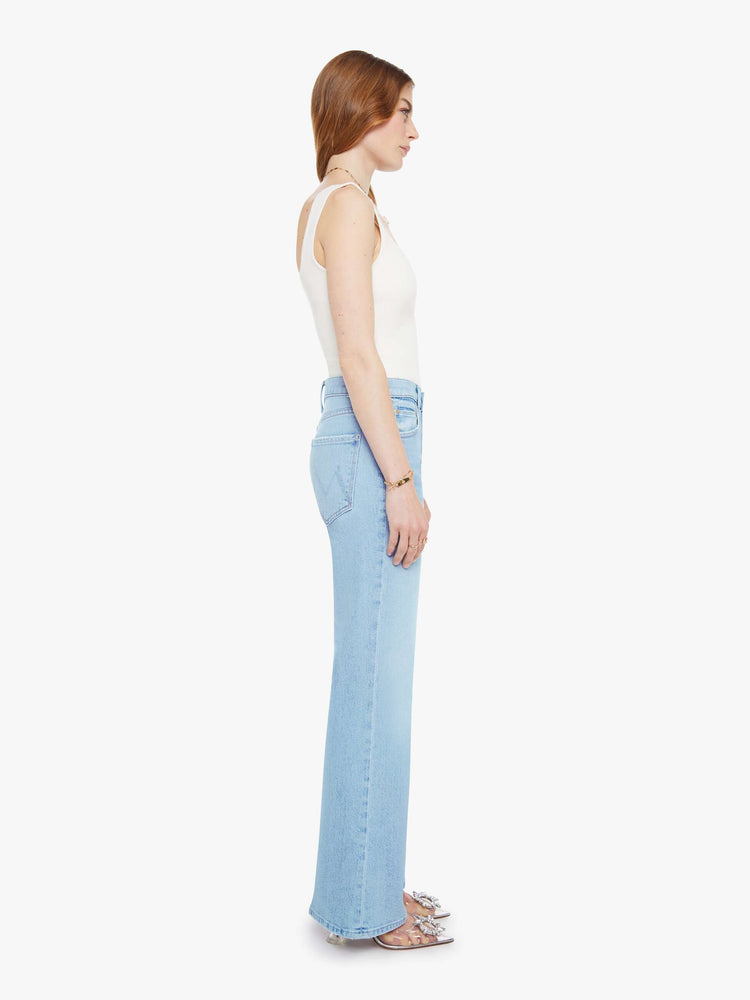 Side view of a woman in a light blue  jean with a high-rise bootcut with a zip fly, looser leg and a long 32-inch inseam with a clean hem. 

