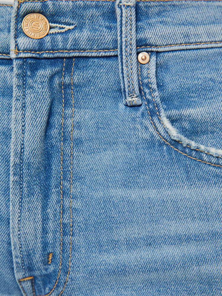 Swatch view of a woman in a light blue mid-rise bootcut with a zip fly, looser leg and a long 32-inch inseam with a clean hem.