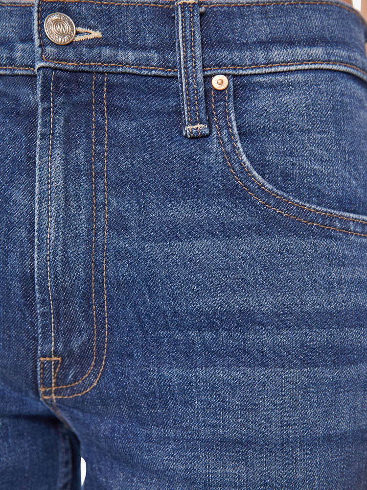 Swatch view of a woman in a dark blue high-rise bootcut jean with a zip fly, looser leg and a long 32-inch inseam with a clean hem.