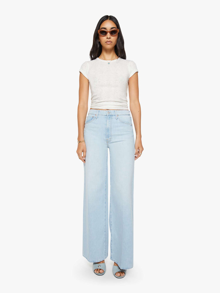 Front view of a woman in a light blue wide-leg jeans feature a high rise with a slightly dropped crotch, zip fly, low-set back pockets and a 31-inch inseam.
