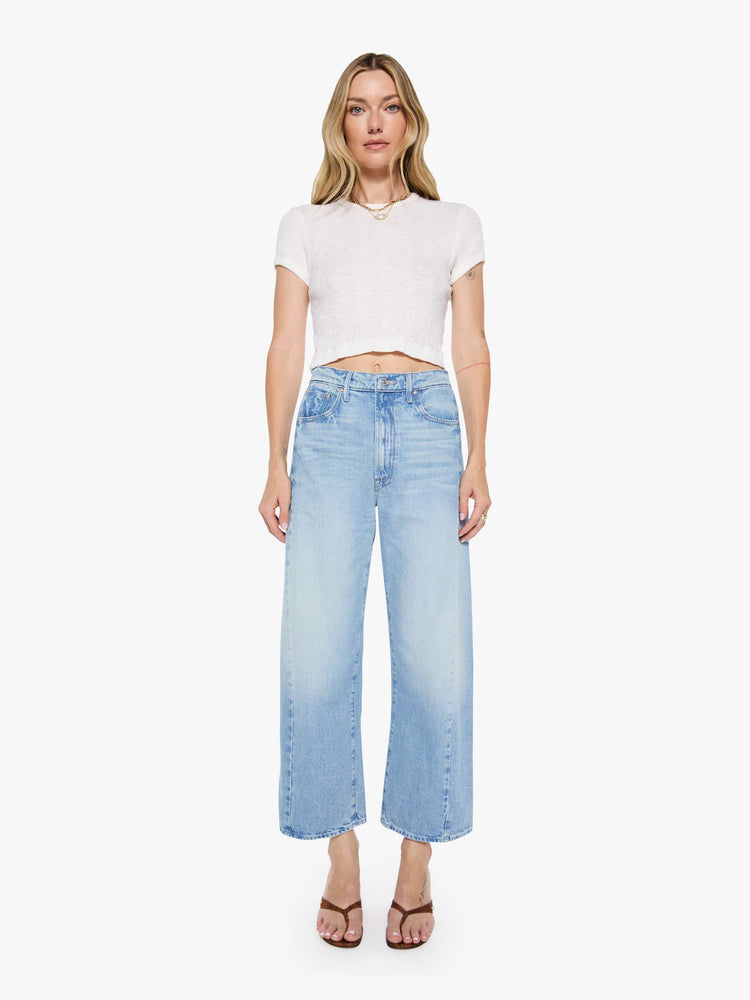 Front view of a woman super high-waisted jean with a wide, curved leg, an ankle-length inseam and a clean hem in a light blue wash.