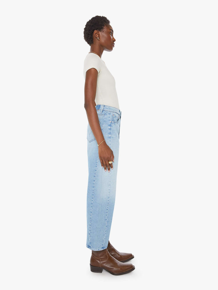 Side view of a woman super high-waisted jean with a wide, curved leg, an ankle-length inseam and a clean hem in a light blue wash.