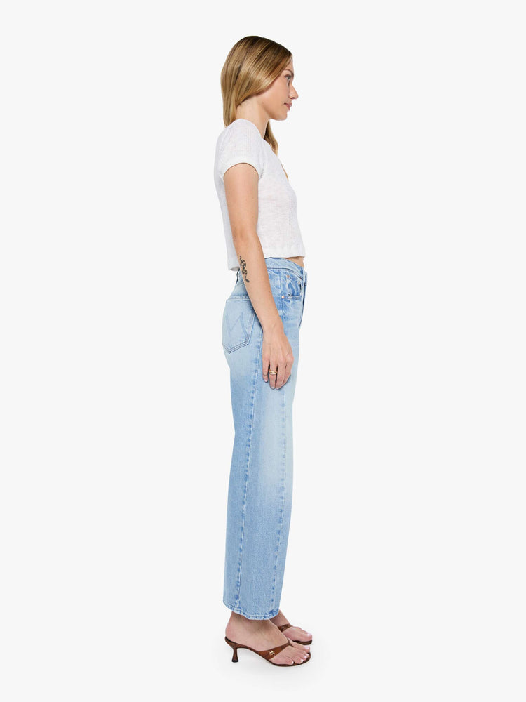 Side view of a woman super high-waisted jean with a wide, curved leg, an ankle-length inseam and a clean hem in a light blue wash.