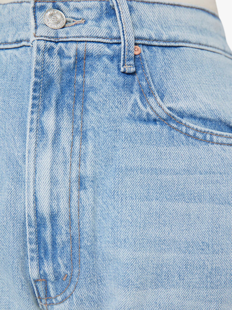 Front close up view of a a light blue wash jean with contrast brown thread.