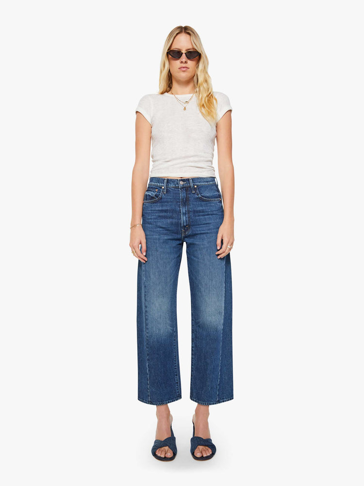 Front view of a woman in a dark blue super high-waisted jean with a wide, curved leg, an ankle-length inseam and a clean hem.