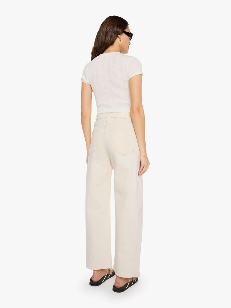 Back view of a woman in a cream white pant with super high-waisted jean with a wide, curved leg, an ankle-length inseam and a clean hem.