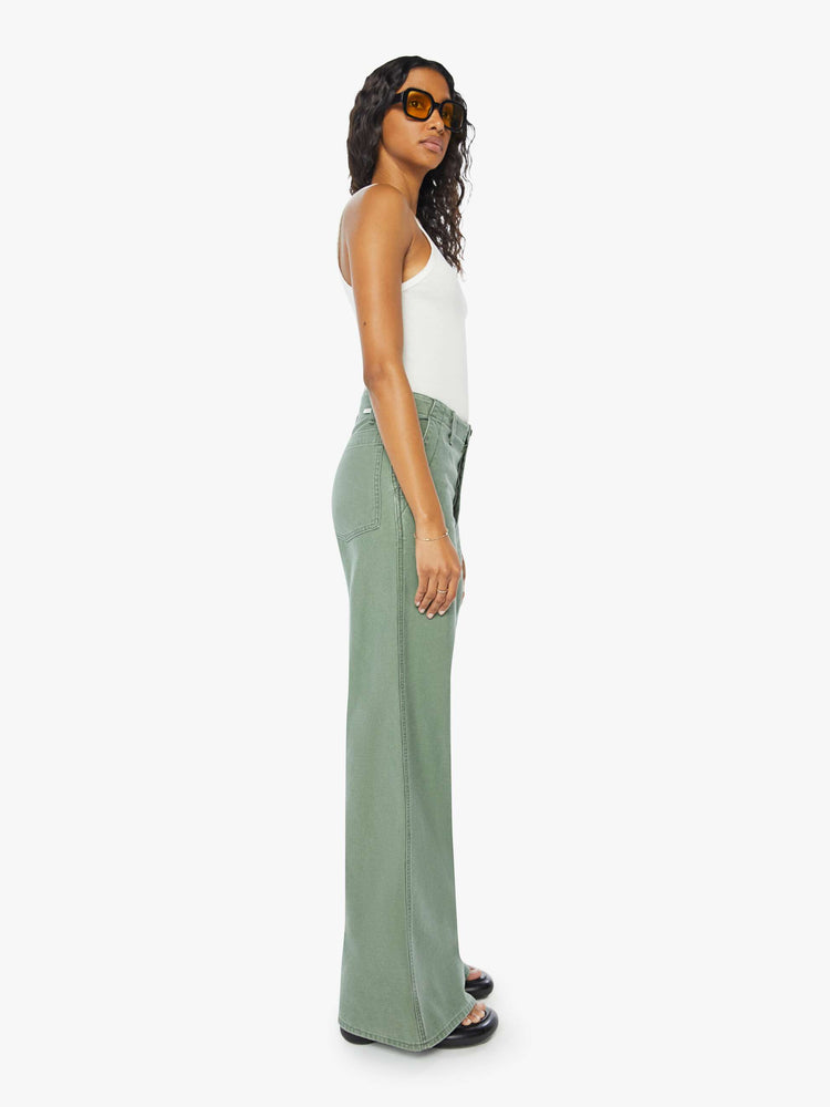 Side view of a womens army green pant featuring a high rise, a wide leg, and a long inseam with clean hem.