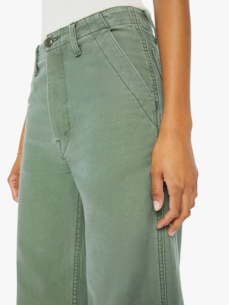 Side close up view of a womens army green pant featuring a high rise and a wide leg.