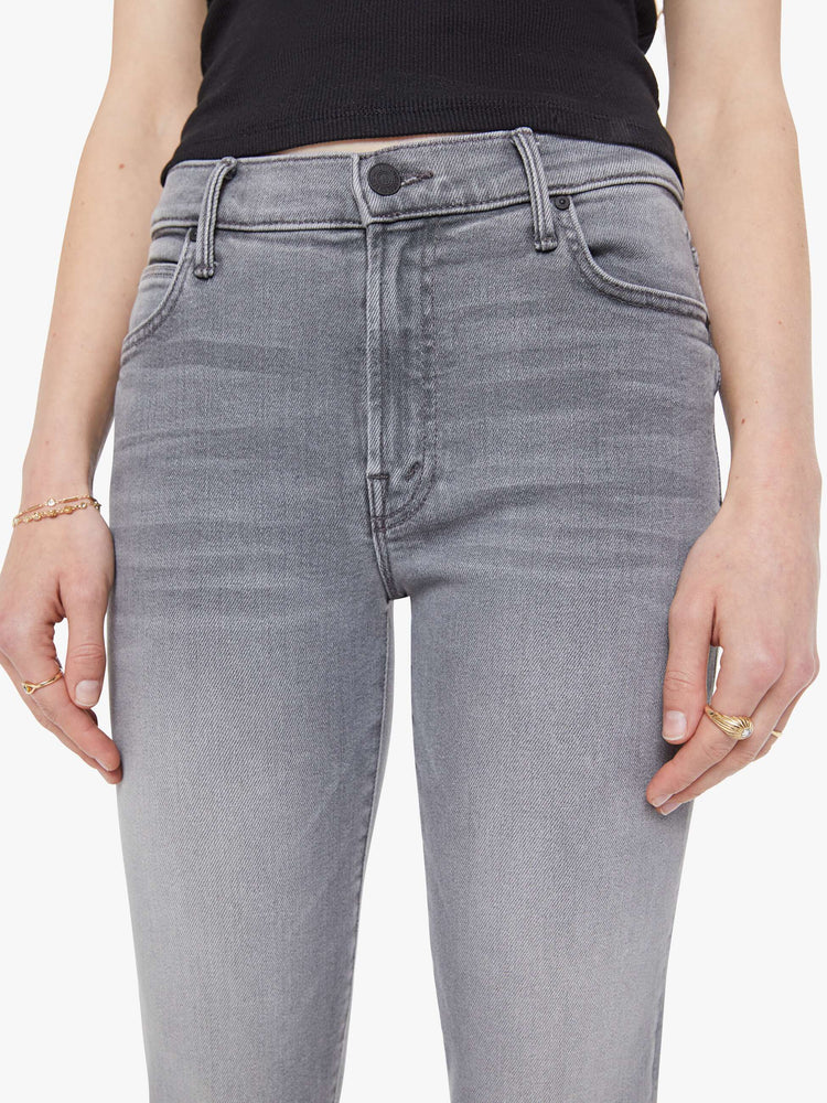 Close up view of a woman in a light grey mid-rise straight leg with a zip fly, 29-inch inseam and a clean hem.