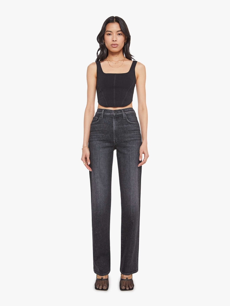 Front view of a woman in a washed black high-waisted jeans with a wide straight leg, zip fly and a long 34-inch inseam with a clean hem.