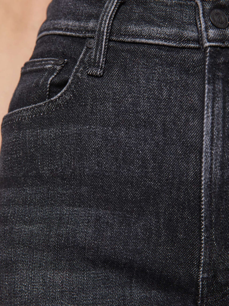 Swatch view of a woman in a washed black high-waisted jeans with a wide straight leg, zip fly and a long 34-inch inseam with a clean hem.