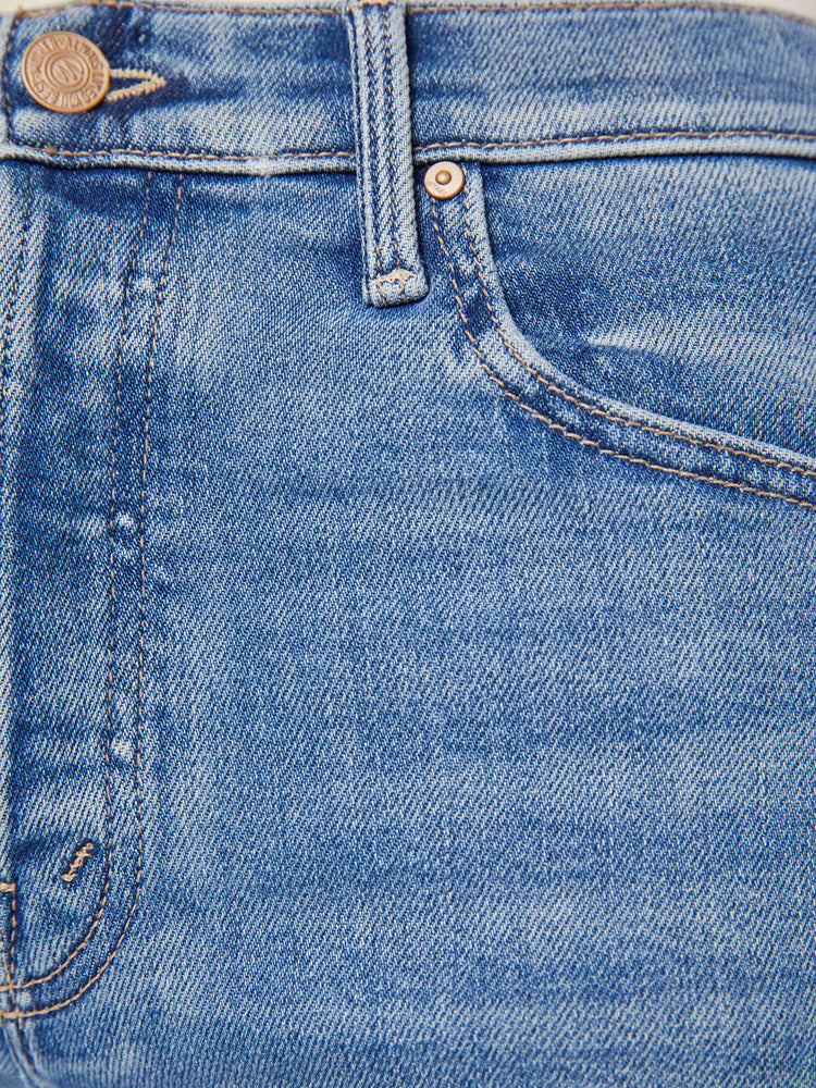Swatch view of a woman in a med blue high-waisted wide-leg jeans with a button fly, long 32-inch inseam and a frayed hem.