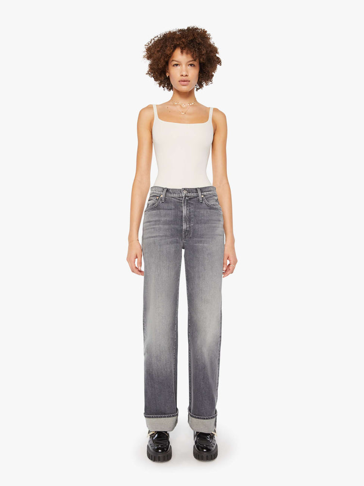 Front view of a woman in grey washed jeans designed to sit lower on the hips with a zip fly, loose wide leg and a 31-inch inseam with a cuffed hem.