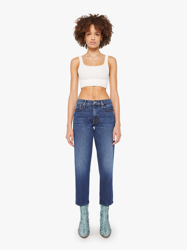 Front view of a woman in a dark blue  high-rise skinny-straight jeans have a zip fly, an ankle-length inseam and a clean hem. 