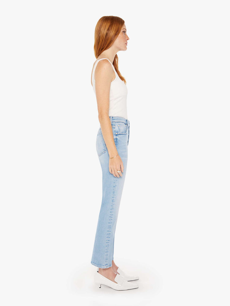 Side view of a woman high-rise flare with a button fly and 28.25-inch inseam with a clean hem in a light blue wash.