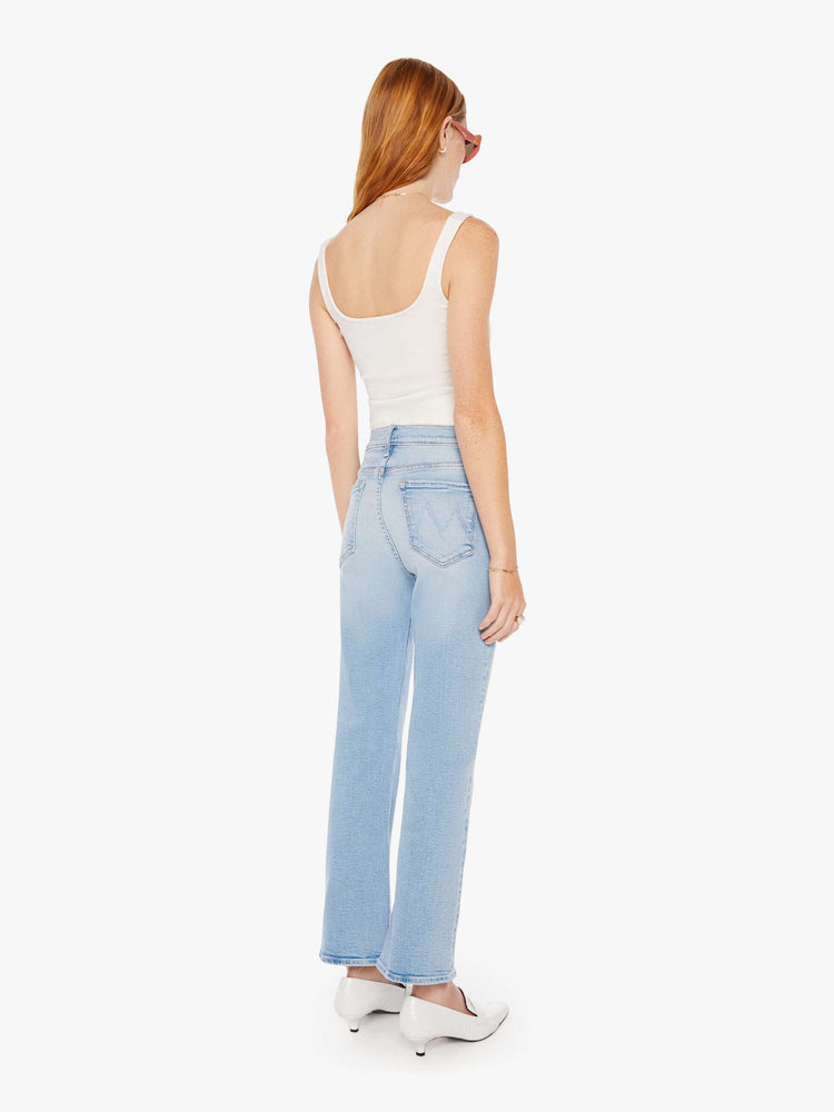 Back view of a woman high-rise flare with a button fly and 28.25-inch inseam with a clean hem in a light blue wash.