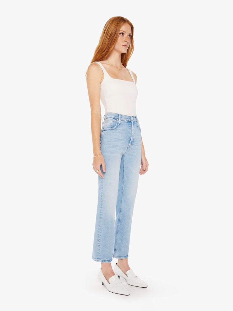 Side front view of a woman high-rise flare with a button fly and 28.25-inch inseam with a clean hem in a light blue wash. 