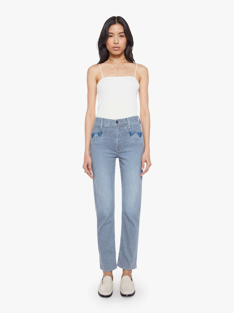 Front view of a woman in a midblue with white vertical stripes with high-rise jeans with a straight leg, zip fly, diamond cut-out details, an ankle-length inseam and a clean hem.