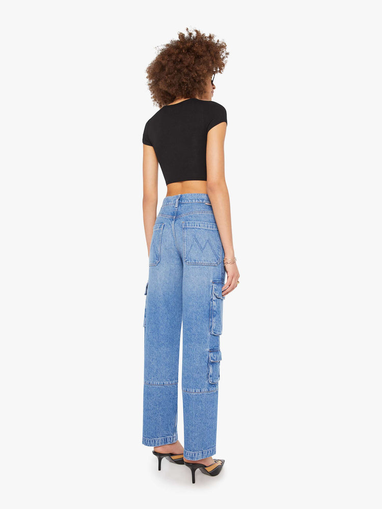 Back view of a woman in a mid blue high-waisted jeans have a wide leg, zip fly, cargo-inspired patch pockets, a long 31-inch inseam and a clean hem.