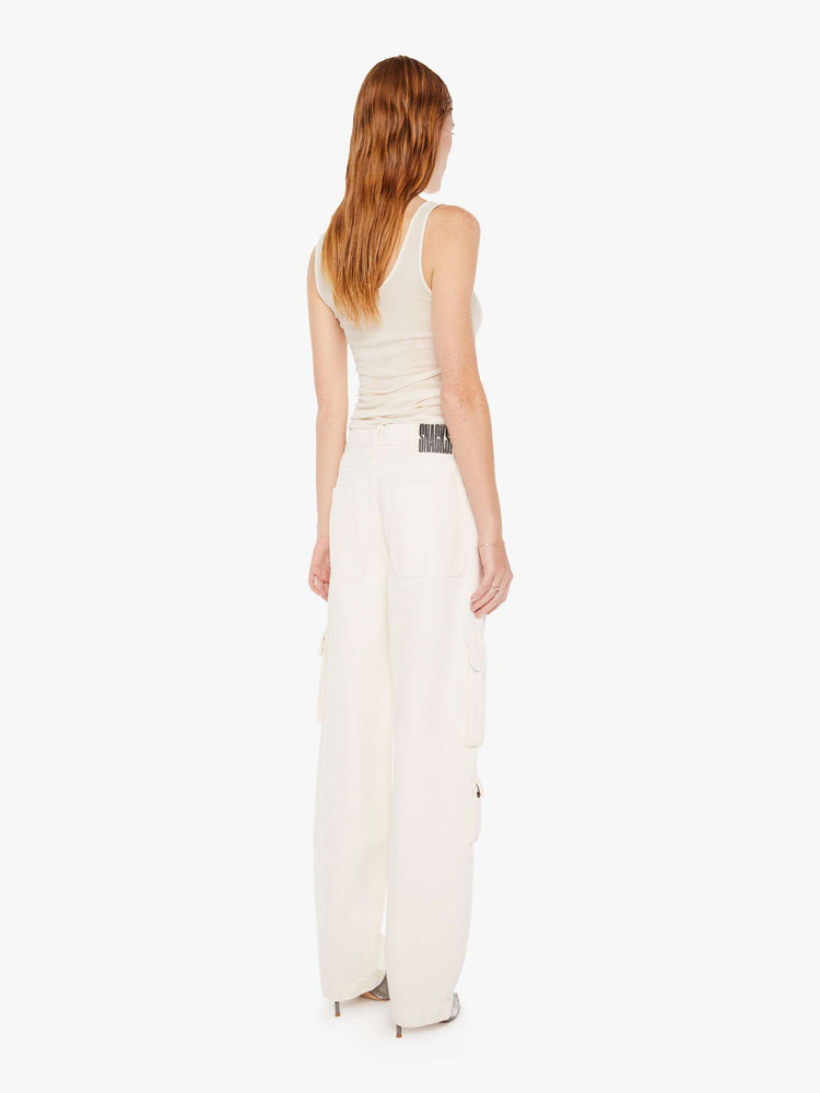 Back view of a womens off white cargo jean featuring a relaxed mid rise, cargo pockets, and a clean hem.