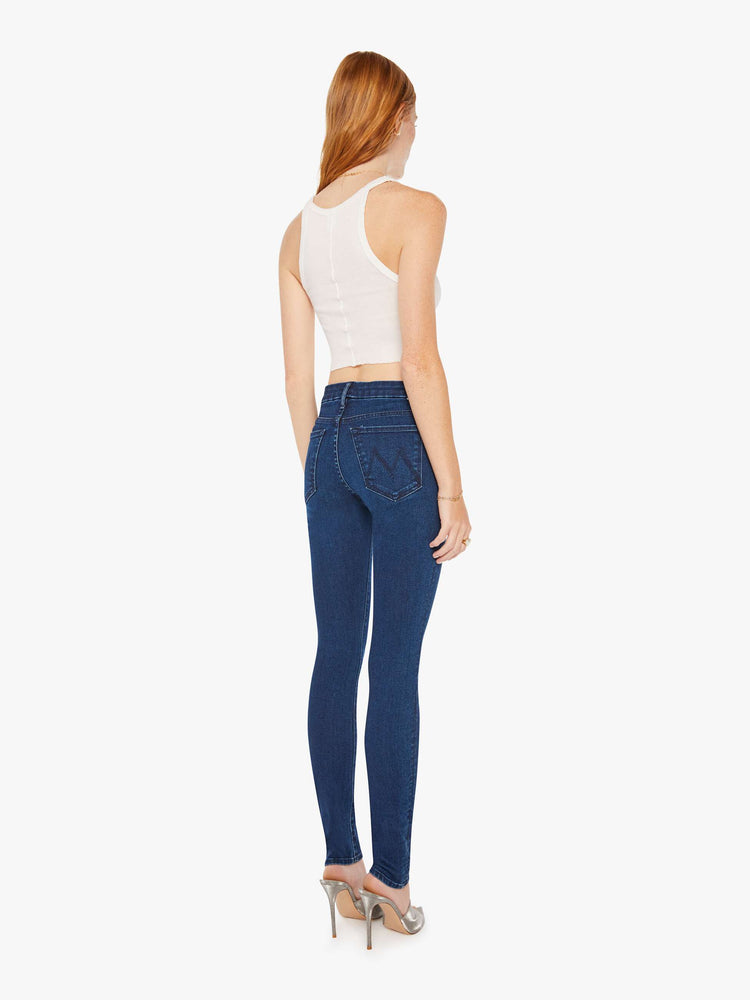 Back view of a woman cult-favorite skinny with a mid rise and a 31-inch inseam with a clean hem in a dark blue wash.