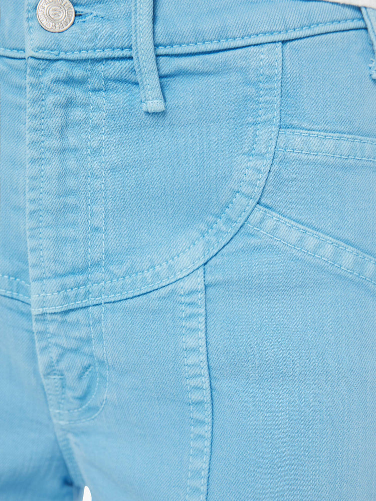 Swatch view of a woman in a light blue wide leg jeans with a high rise, zip fly, sun-shaped seamed details at the waist, a long 32-inch inseam and a clean hem.