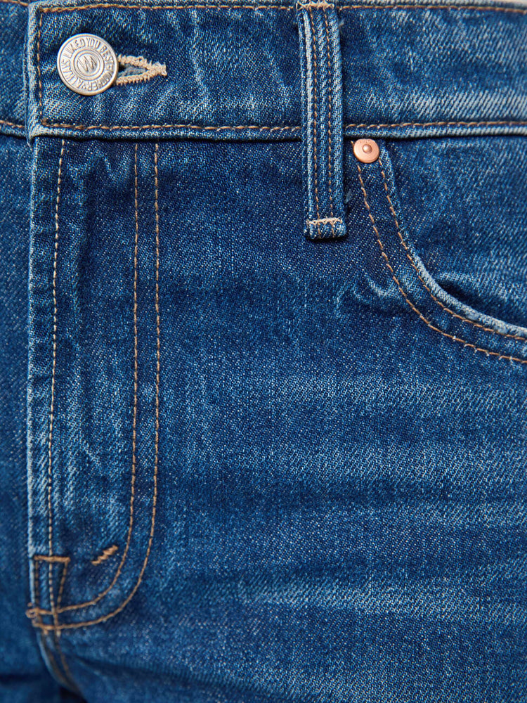 Swatch view of a woman in mid blue mid-rise jeans with a wide straight leg, zip fly and long 31-inch inseam with a clean hem. 