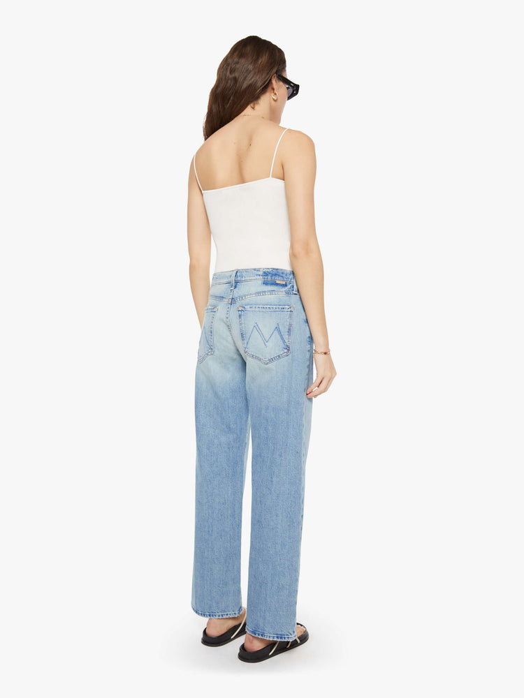 Back view of a woman  in a light blue mid-rise jeans with a wide straight leg, zip fly and long 32-inch inseam with a clean hem.