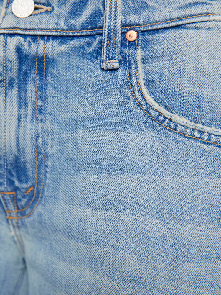 Close up view of a woman  in a light blue mid-rise jeans with a wide straight leg, zip fly and long 32-inch inseam with a clean hem.