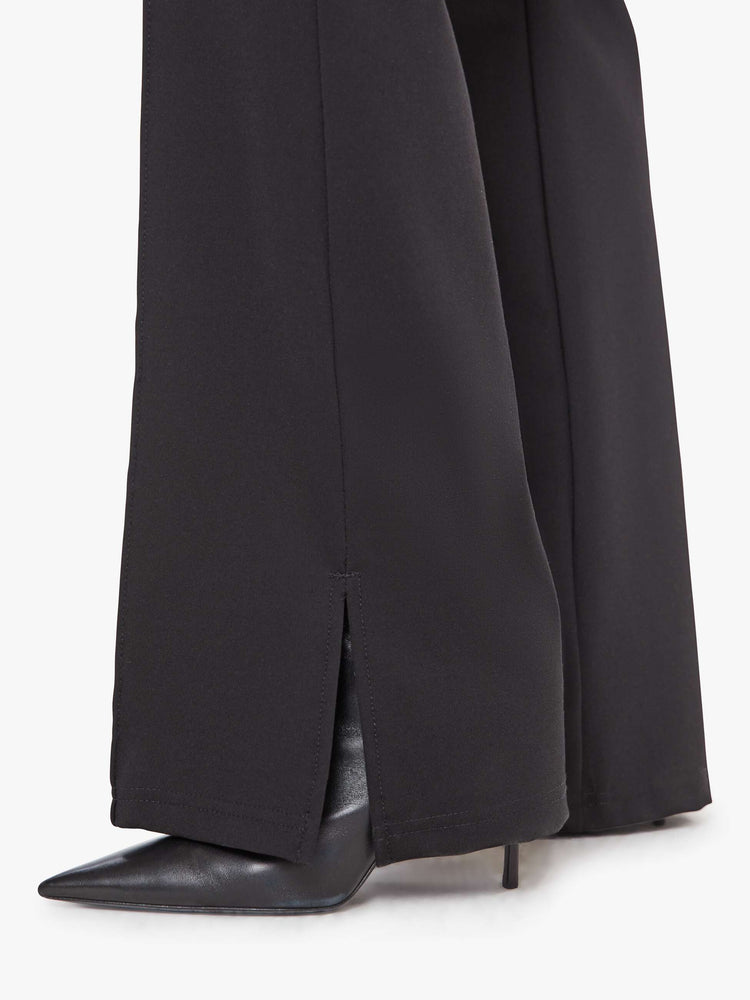 Hem view of a woman in a high-rise bootcut trouser with a zip fly, looser leg, pintuck details down the front, a long 34-inch inseam and a slit hem. 